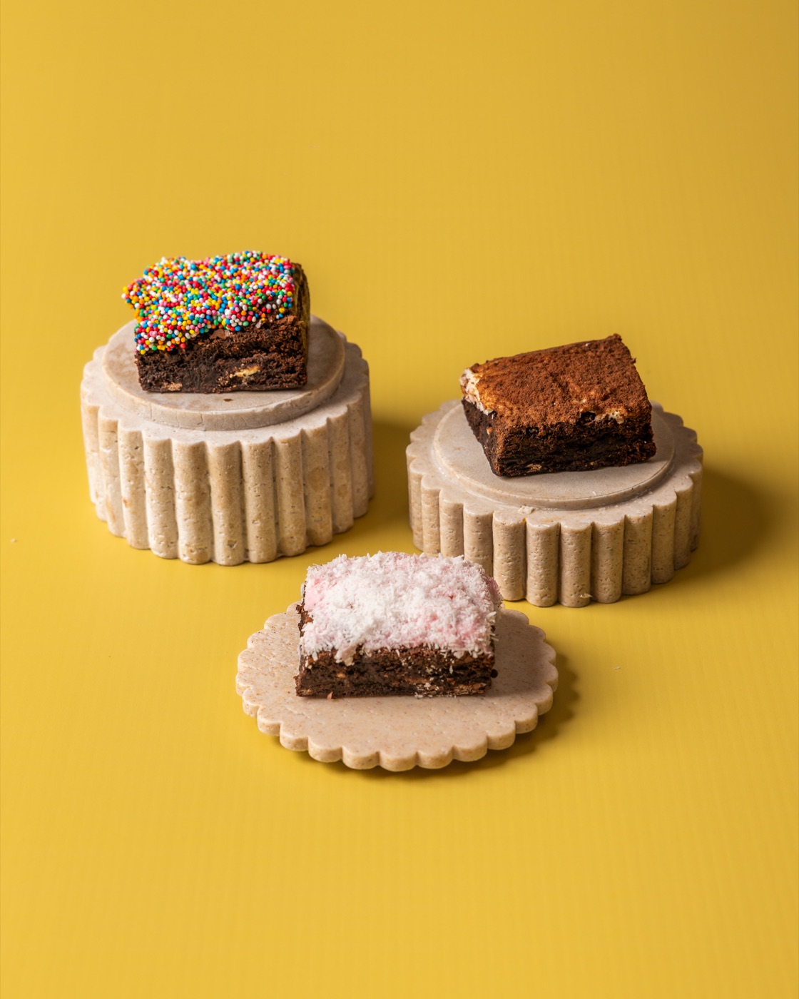 Brownies and sweet slices on stone stands