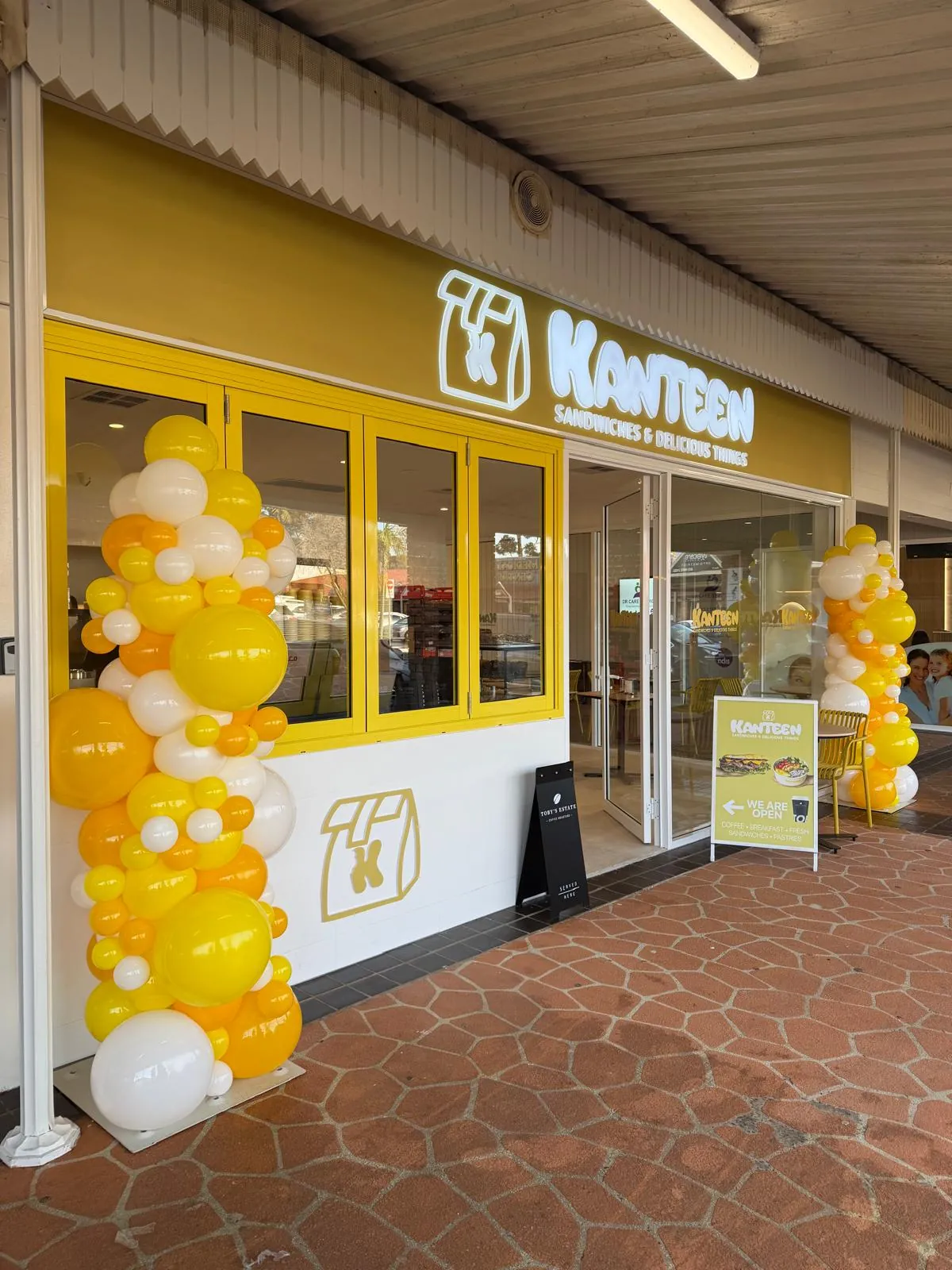 The Kanteen shopfront on Stockton Avenue, Moorebank, with yellow and white balloons at the door